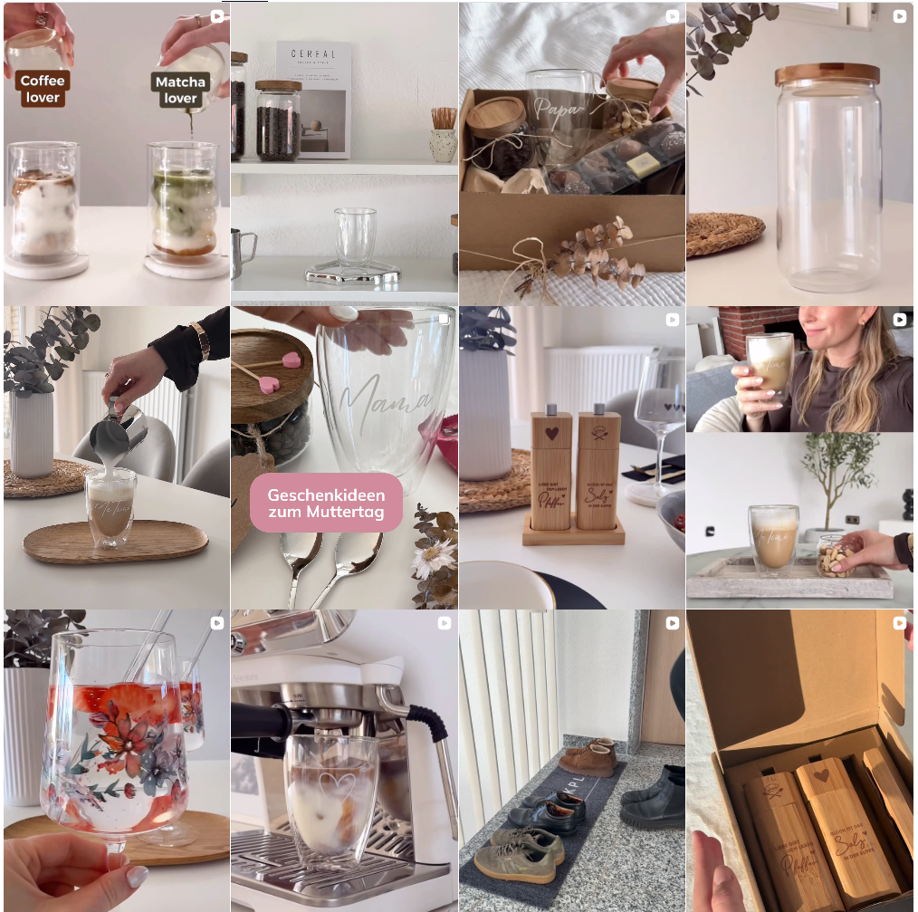 Ein quadratischer Ausschnitt des ElbFuchs Instagram-Feeds, dargestellt als harmonische Bilder-Collage im Grid-Layout. Das Raster zeigt eine Vielzahl von ästhetischen Lifestyle- und Produktfotos: doppelwandige Thermo-Kaffeegläser mit feinen Gravuren für Eltern, stilvolle Vorratsgläser mit edlen Holzdeckeln, florale Aperitifgläser mit sommerlichen Drinks, das gravierte Salz- und Pfeffermühlen-Set aus Bambus sowie die praktische Kokos-Schuhmatte im Eingangsbereich. Ein rosa Sticker mit der Aufschrift 'Geschenk