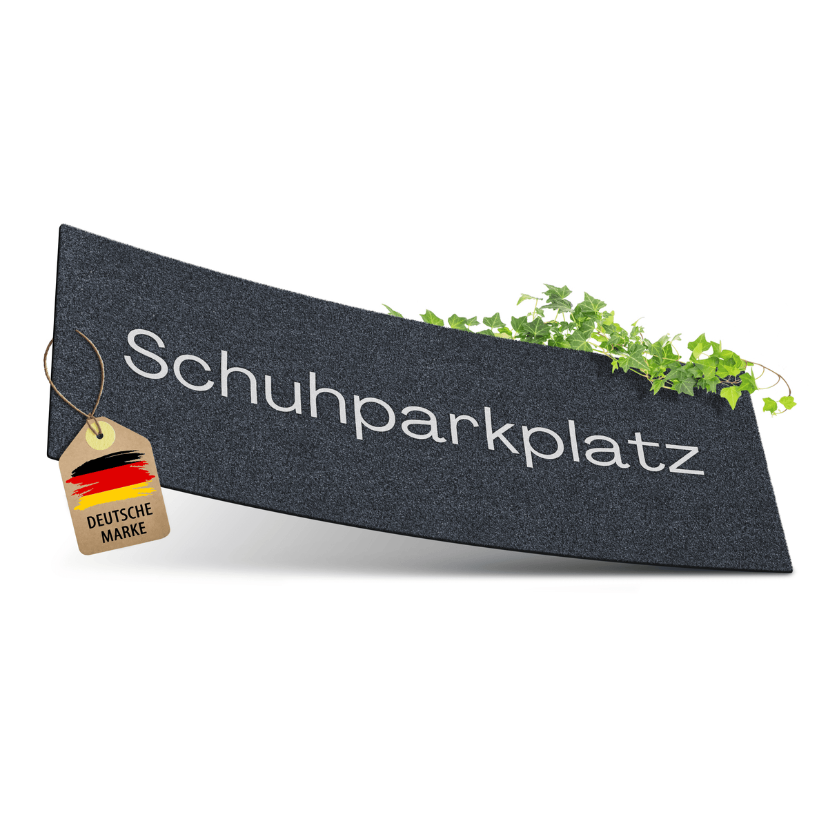Eine anthrazitfarbene ElbFuchs Schuhparkplatz Fußmatte mit eingewebtem Schriftzug 'Schuhparkplatz', dekoriert mit grünem Efeu und einem Anhänger 'Deutsche Marke', freigestellt vor weißem Hintergrund.