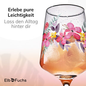 Nahaufnahme eines ElbFuchs Aperitifglases der Serie Rosé Garden mit handgemaltem Blumenmotiv aus rosa und violetten Blüten, gefüllt mit eisgekühltem Rosé und feinen Kondenströpfchen am Glas.