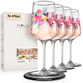Vierer-Set der ElbFuchs Aperitifgläser 'Rosé Garden' mit floralem Rosenmotiv, gefüllt mit rosé Getränk und Eis, aufgereiht neben der Verpackung auf einer schwarzen Schieferplatte.
