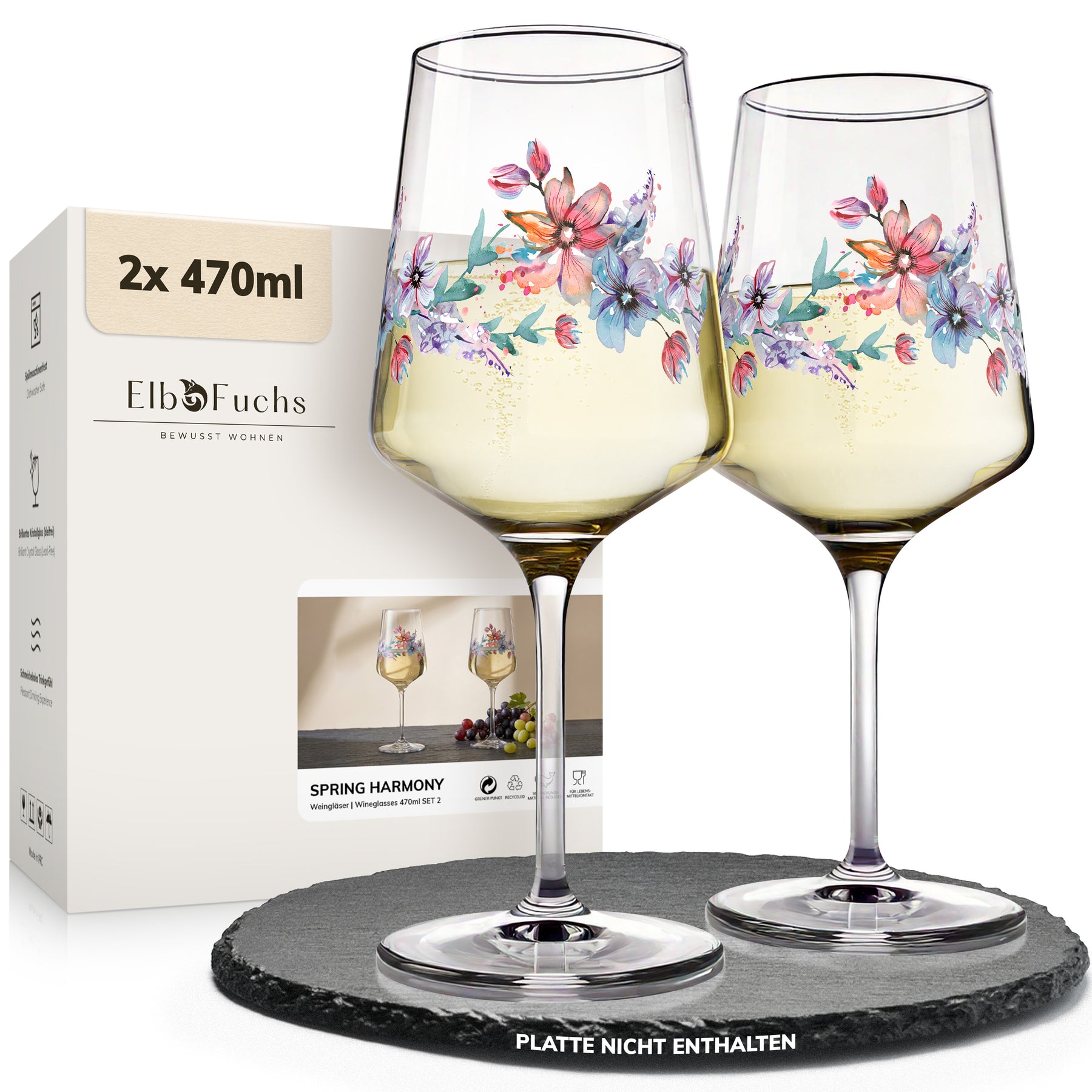 Zwei ElbFuchs Weingläser 'Spring Harmony' mit bunten Blütenranken, gefüllt mit hellem Weißwein, stehen auf einer Schieferplatte neben der cremefarbenen Geschenkbox.
