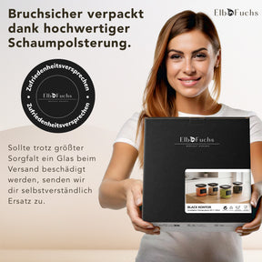 Frau hält die schwarze ElbFuchs BLACK KONTOR Geschenkbox mit Zufriedenheitssiegel – bruchsicher verpackt in Schaumpolsterung.