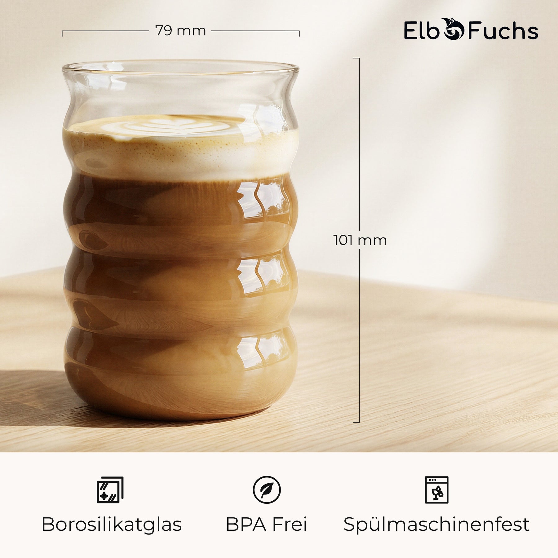 Ein ElbFuchs BYSKE Glas mit Latte Macchiato auf einem Holztisch, mit eingezeichneten Maßen von 79mm Durchmesser und 101mm Höhe sowie Hinweisen auf Borosilikatglas, BPA-Freiheit und Spülmaschinenfestigkeit.