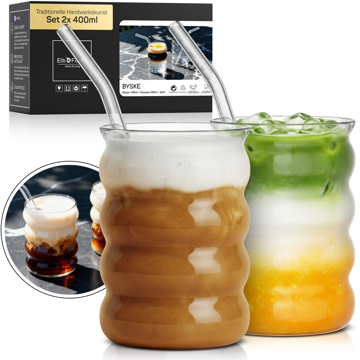 Zwei ElbFuchs BYSKE Gläser im Set 2x 400ml, gefüllt mit Iced Coffee und Iced Matcha Latte samt Eiswürfeln und Glasstrohhalmen, mit Verpackung und einer Nahaufnahme im Hintergrund.
