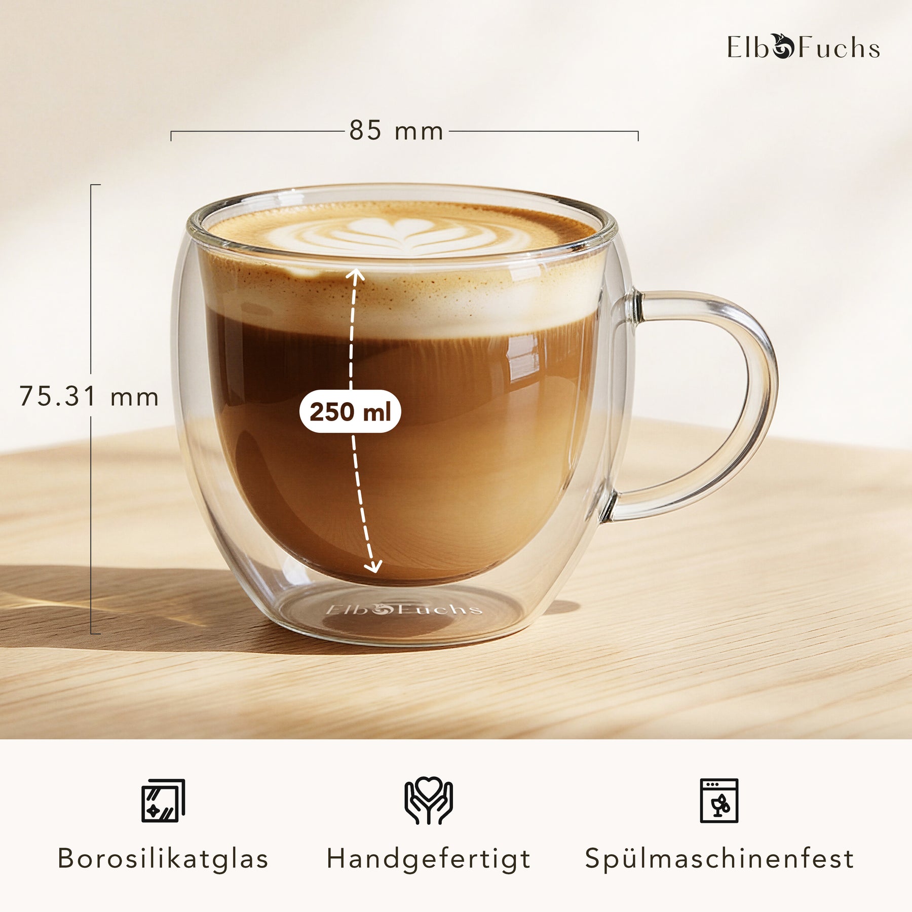 Ein doppelwandiges ElbFuchs VIENNA Kaffeeglas mit Henkel, gefüllt mit Cappuccino und feiner Latte-Art, mit eingeblendeten Maßen von 85 mm Durchmesser und 250 ml Fassungsvermögen aus handgefertigtem, spülmaschinenfestem Borosilikatglas.