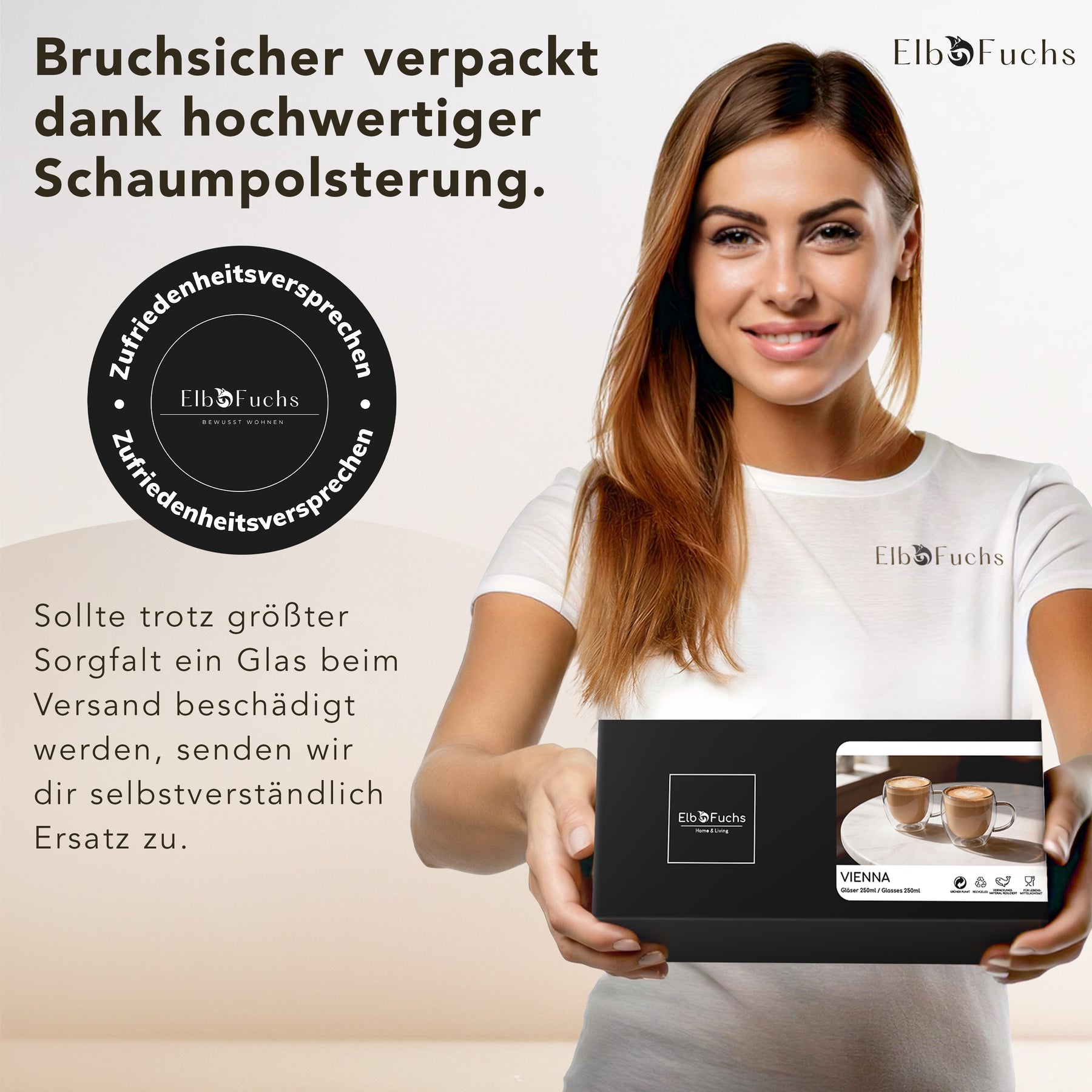 Eine lächelnde Frau im weißen ElbFuchs T-Shirt hält eine schwarze VIENNA Geschenkbox mit Zufriedenheitssiegel in den Händen, deren stoßfeste Schaumpolsterung die doppelwandigen Kaffeegläser sicher vor Bruch beim Versand schützt.