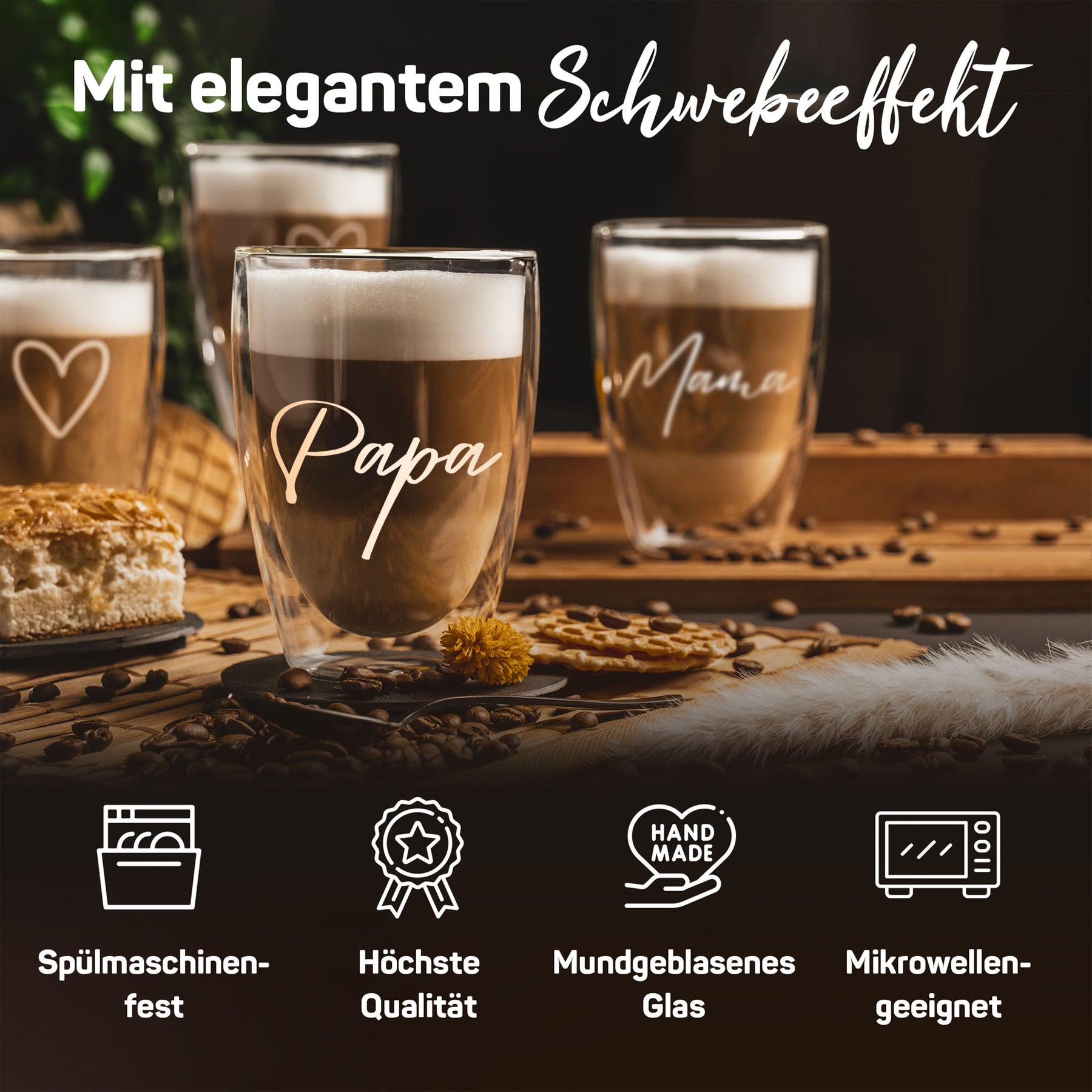 Vier doppelwandige ElbFuchs Gläser mit dampfendem Latte Macchiato auf einem Holztisch, in der Mitte mit goldener Gravur 'Papa', daneben ein Glas mit filigraner Herzgravur und eines mit dem Schriftzug 'Mama', umgeben von Kaffeebohnen und Gebäck vor dunklem Hintergrund.