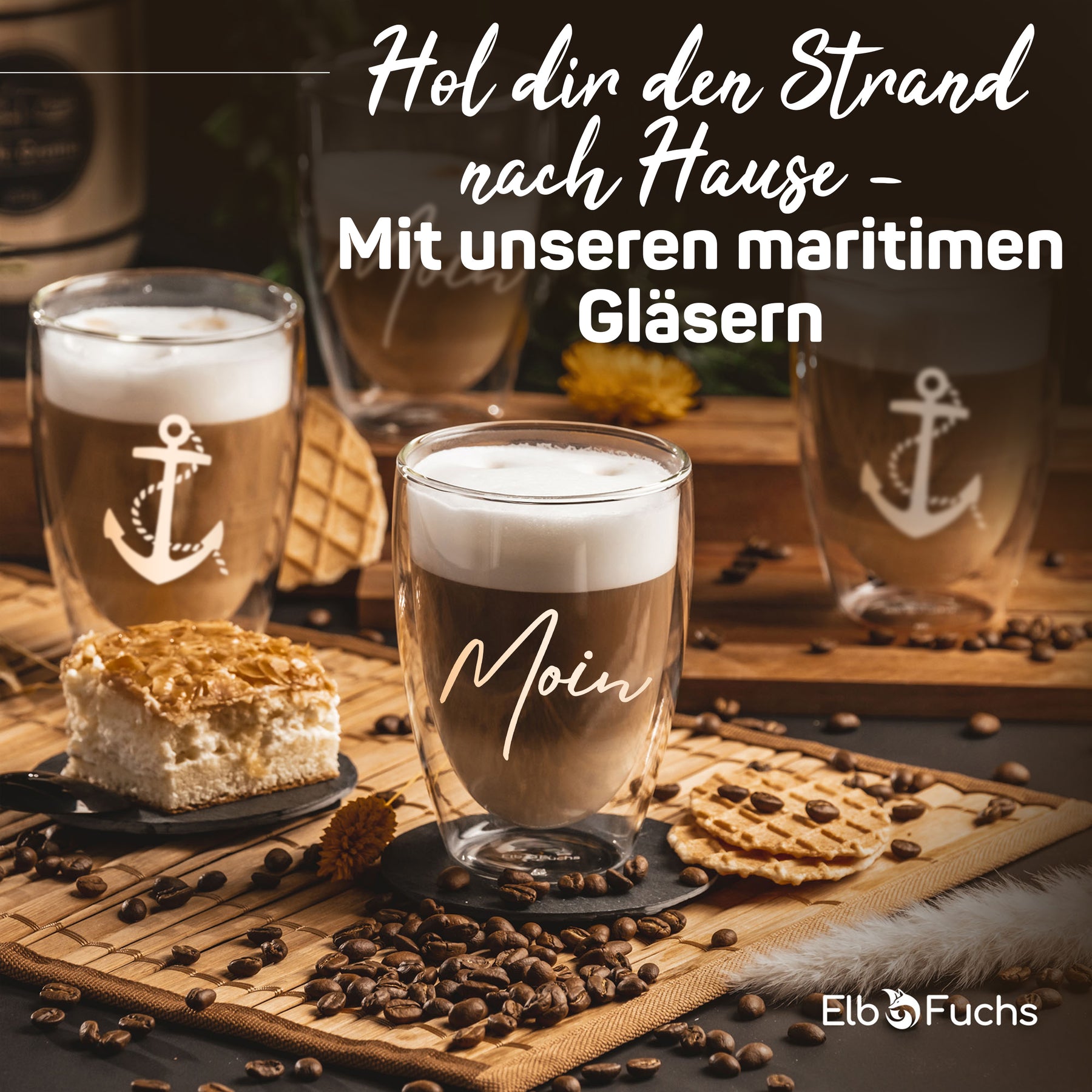 Maritime Tischszene mit ElbFuchs Thermogläsern, verziert mit Anker-Motiv und der Gravur 'Moin', gefüllt mit Latte macchiato und umgeben von Kaffeebohnen, Gebäck und einer Torte.