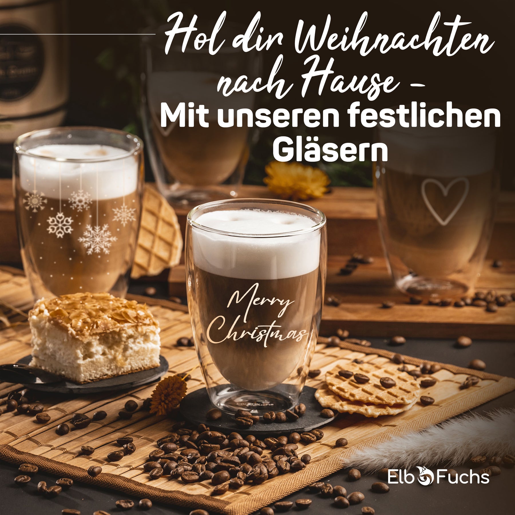 Weihnachtliche Tischszene mit ElbFuchs Thermogläsern gefüllt mit Latte macchiato, umgeben von Kaffeebohnen, Gebäck und einer Torte, im Hintergrund ein weiteres Glas mit herzförmiger Gravur.