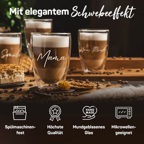 Vier doppelwandige ElbFuchs Gläser mit Latte Macchiato vor dunklem Hintergrund, im Zentrum mit der Gravur 'Mama' und angedeutet die Schriftzüge 'Smile' und 'You Rock', umgeben von Kaffeebohnen und Gebäck auf einer Bambusmatte.