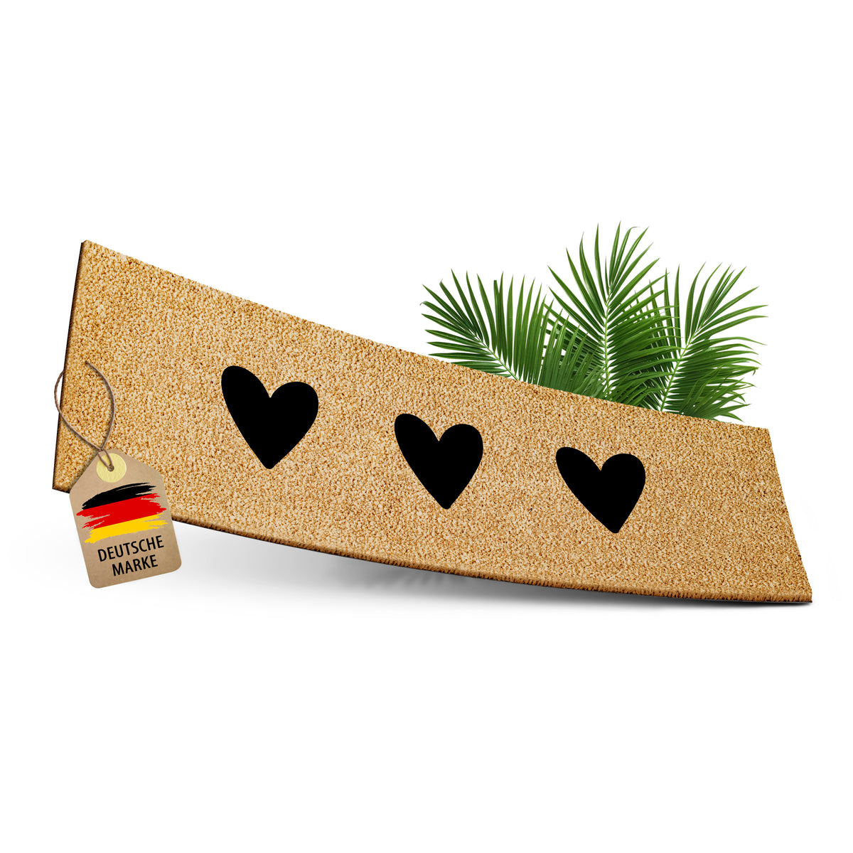 ElbFuchs Kokos-Fußmatte 75x25 cm mit drei schwarzen Herz-Cutouts, leicht gebogen freigestellt vor weißem Hintergrund, mit Anhänger 'Deutsche Marke' und dekorativen Palmblättern.