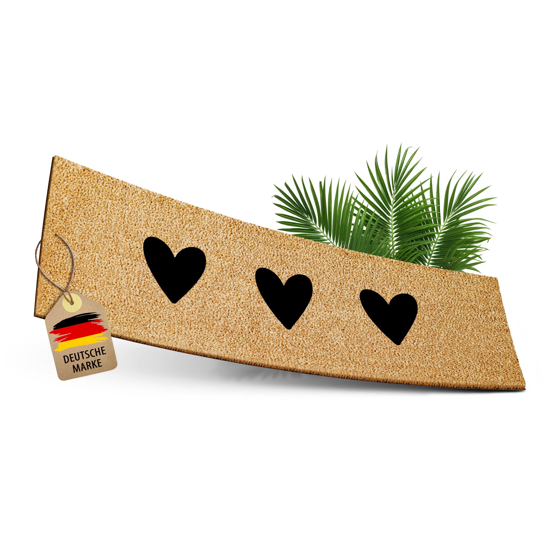 ElbFuchs Kokos-Fußmatte 75x25 cm mit drei schwarzen Herz-Cutouts, leicht gebogen freigestellt vor weißem Hintergrund, mit Anhänger 'Deutsche Marke' und dekorativen Palmblättern.