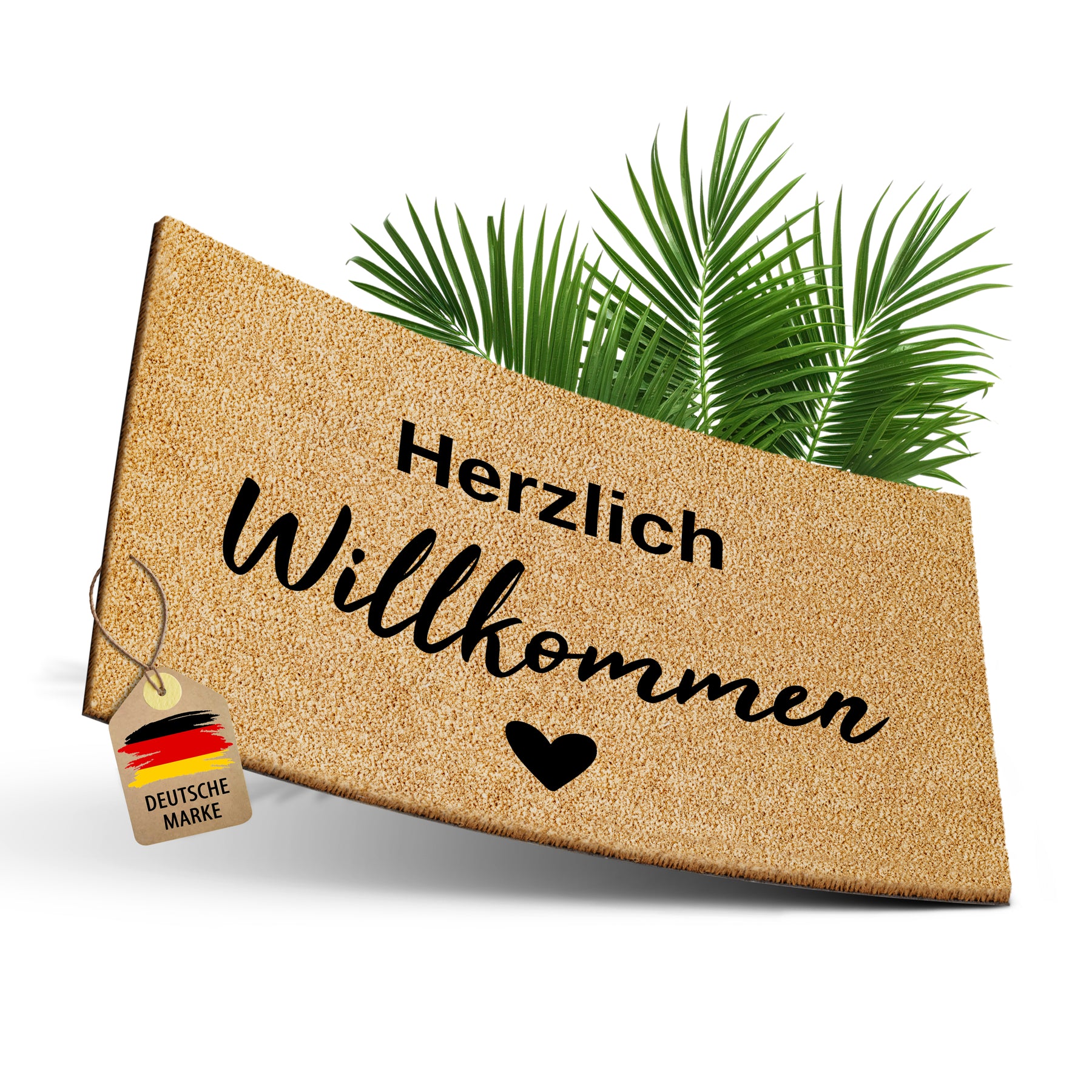 Freigestellte ElbFuchs Kokosfußmatte mit der Gravur „Herzlich Willkommen“ und Herz vor grünen Palmblättern, mit einem Anhänger „Deutsche Marke“ als Hinweis auf die heimische Fertigung.