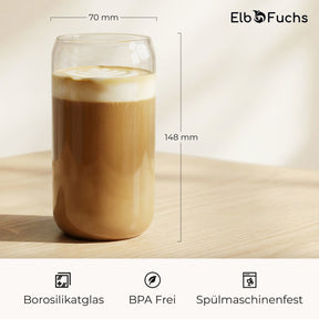 Ein ElbFuchs CERNO Glas mit Latte Macchiato auf einem Holztisch, mit eingezeichneten Maßen von 70mm Durchmesser und 148mm Höhe sowie Hinweisen auf Borosilikatglas, BPA-Freiheit und Spülmaschinenfestigkeit.