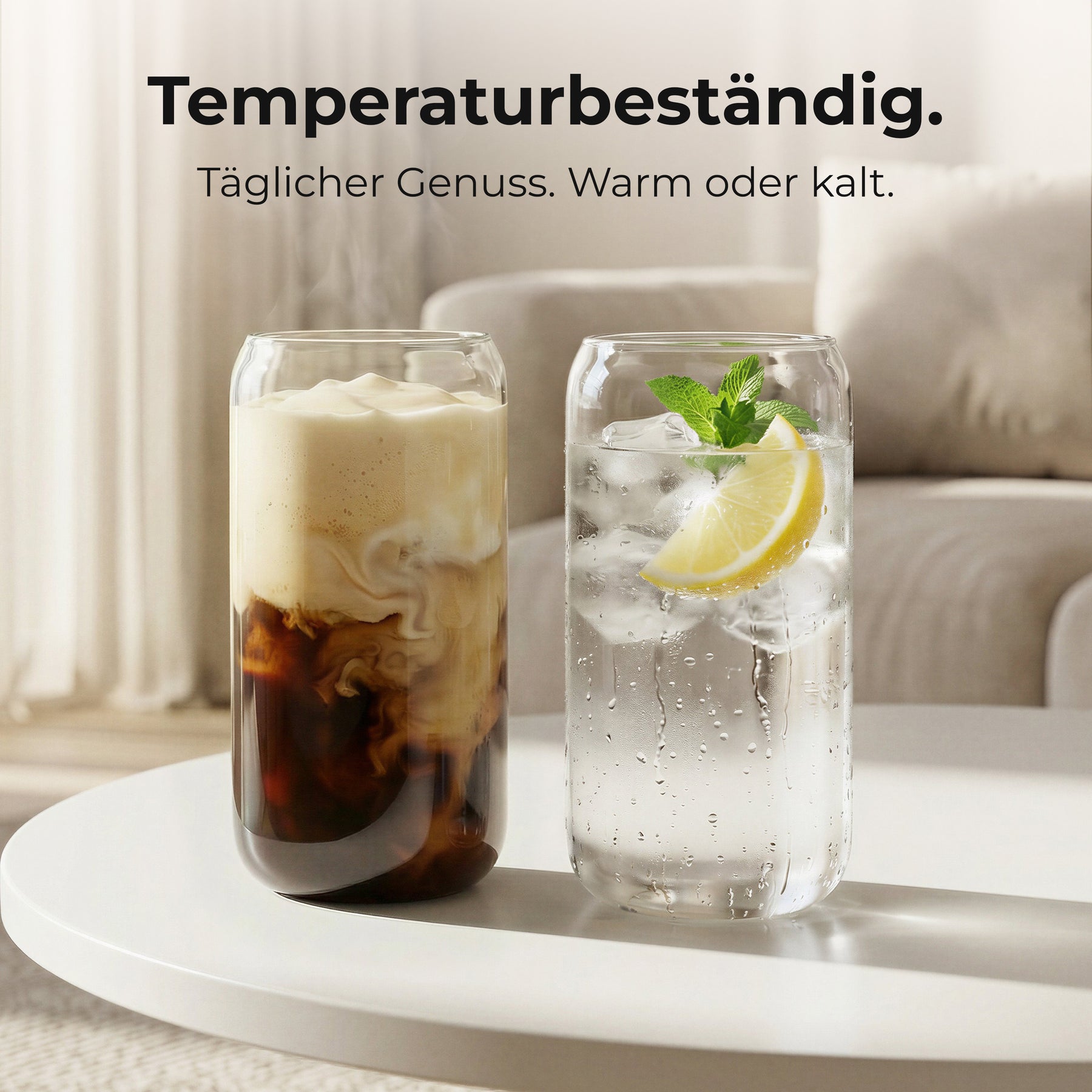 Zwei ElbFuchs CERNO Gläser auf einem runden Couchtisch im Wohnzimmer, eines gefüllt mit cremigem Iced Coffee, das andere mit spritzigem Wasser, Eiswürfeln, Minze und einer Zitronenscheibe, dazu der Hinweis auf die Temperaturbeständigkeit der Gläser.
