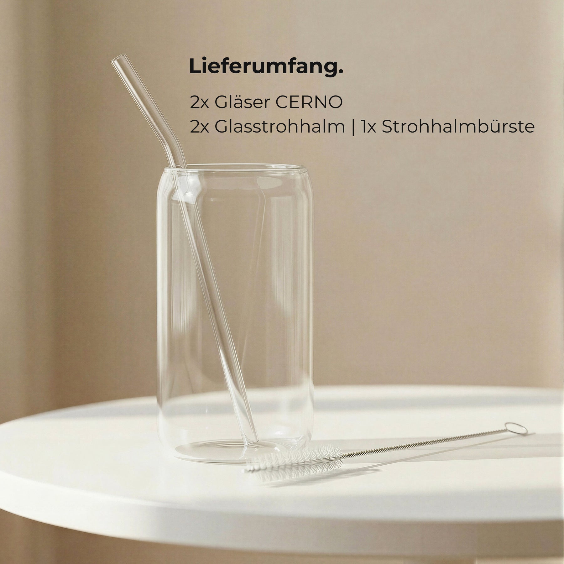 Ein leeres ElbFuchs CERNO Glas mit Glasstrohhalm und Reinigungsbürste auf einem weißen Tisch, daneben der Lieferumfang: 2 Gläser, 2 Glasstrohhalme und eine Strohhalmbürste.