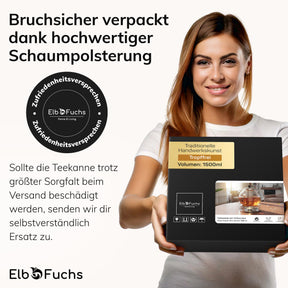 Eine lächelnde Frau im weißen ElbFuchs T-Shirt hält die Geschenkbox der Glasteekanne mit Stövchen und Zufriedenheitssiegel in den Händen, deren Schaumpolsterung einen bruchsicheren Versand der 1500-ml-Kanne gewährleistet.