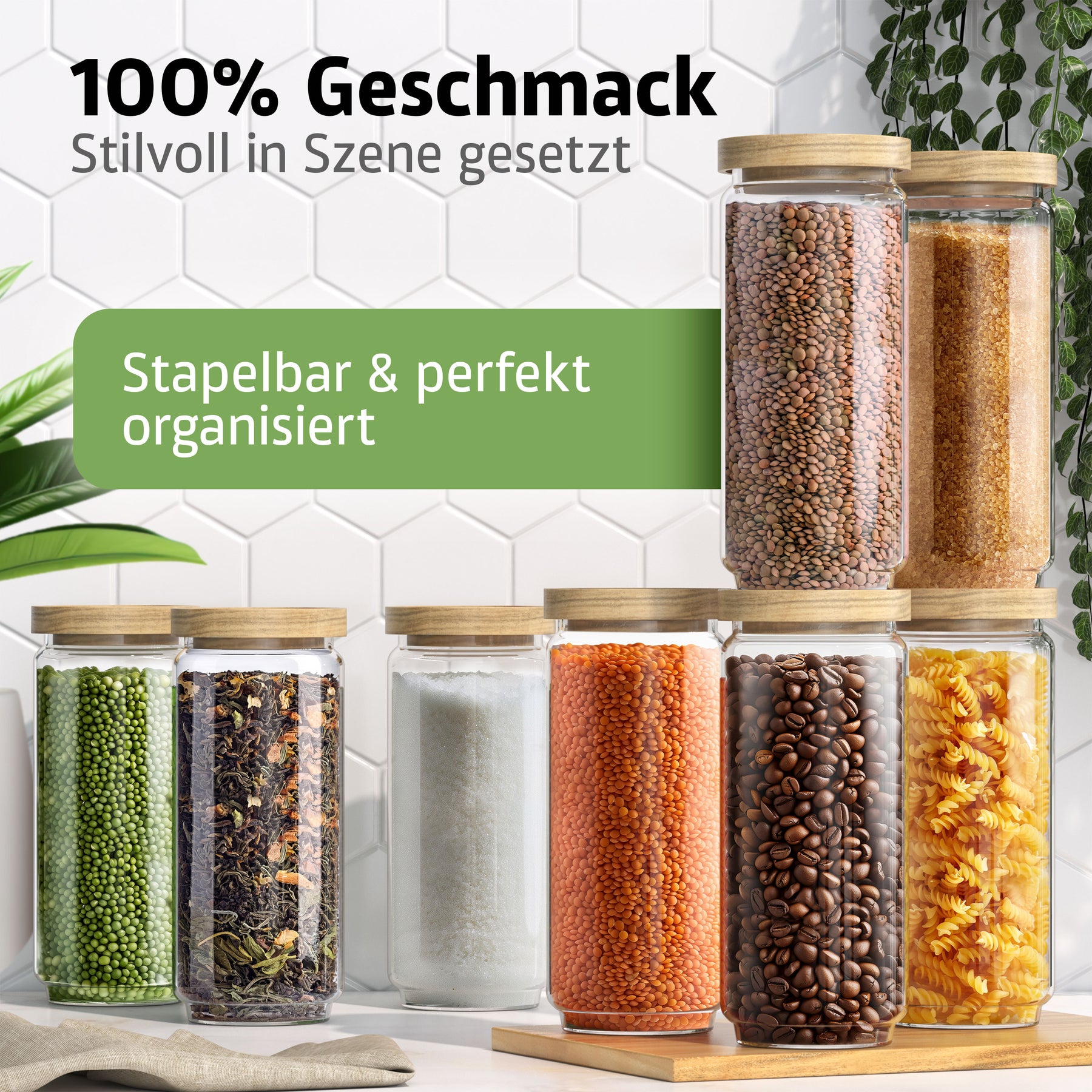 Sechs ElbFuchs Vorratsgläser WOOD KONTOR mit Holzdeckeln sind pyramidenförmig gestapelt und mit grünen Mungbohnen, getrocknetem Tee, Salz, roten Linsen, Kaffeebohnen und braunem Reis gefüllt, vor einer weißen Fliesenwand mit hängender Pflanze.