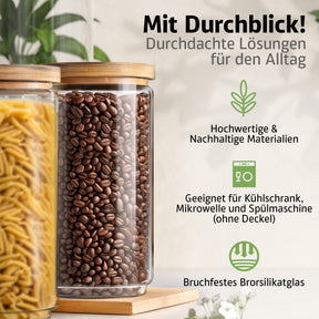 Zwei große ElbFuchs Vorratsgläser mit Bambusdeckel und bruchfestem Borosilikatglas stehen auf einem Holzbrett, das vordere randvoll mit Kaffeebohnen, das andere mit Spaghetti gefüllt, umgeben von zarten weißen Blüten.