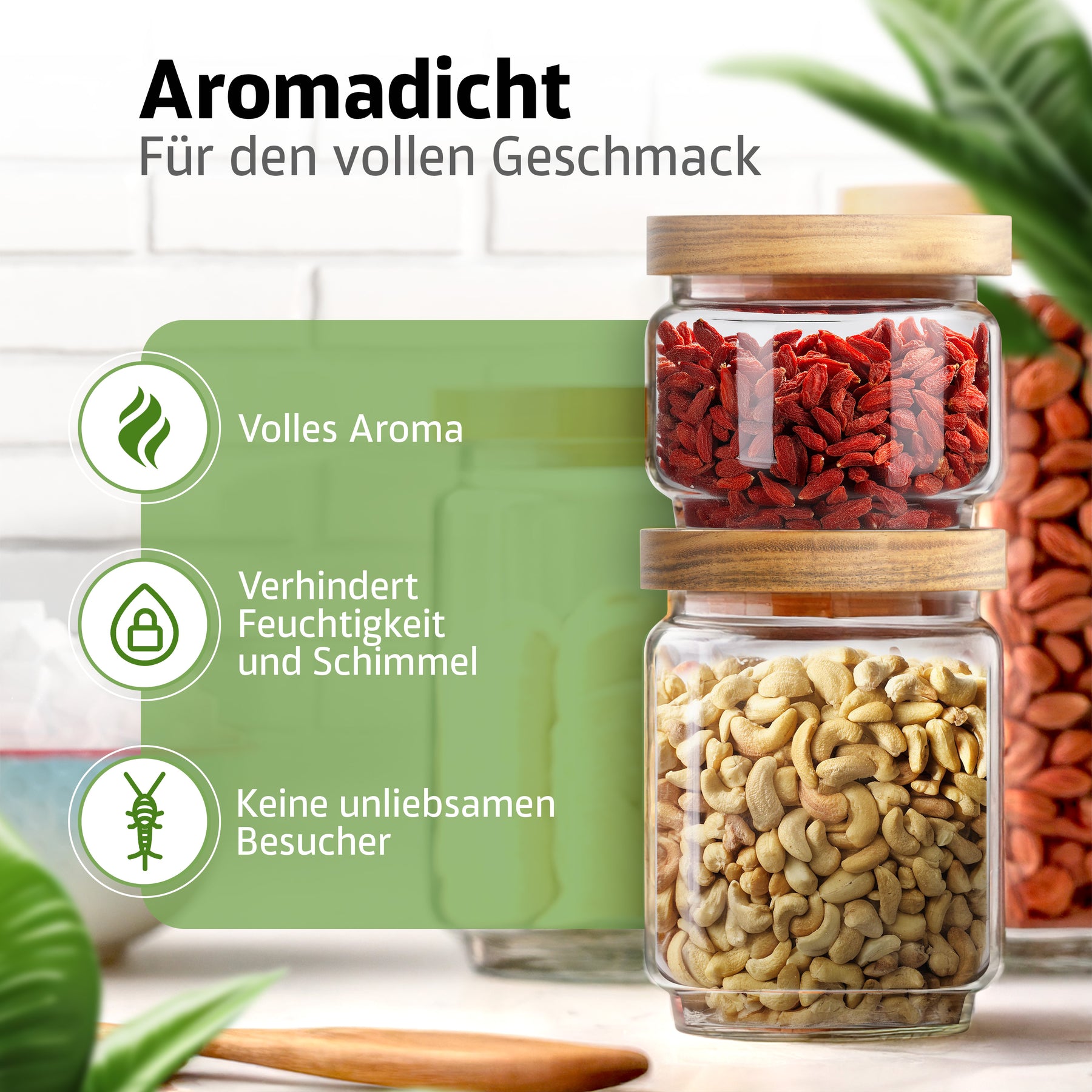 Zwei ElbFuchs Vorratsgläser mit Bambusdeckel stehen gestapelt auf einer Küchenablage, gefüllt mit getrockneten Gojibeeren und Cashewkernen, umgeben von grünen Pflanzenblättern; das aromadichte Verschlusssystem hält den Inhalt frisch.