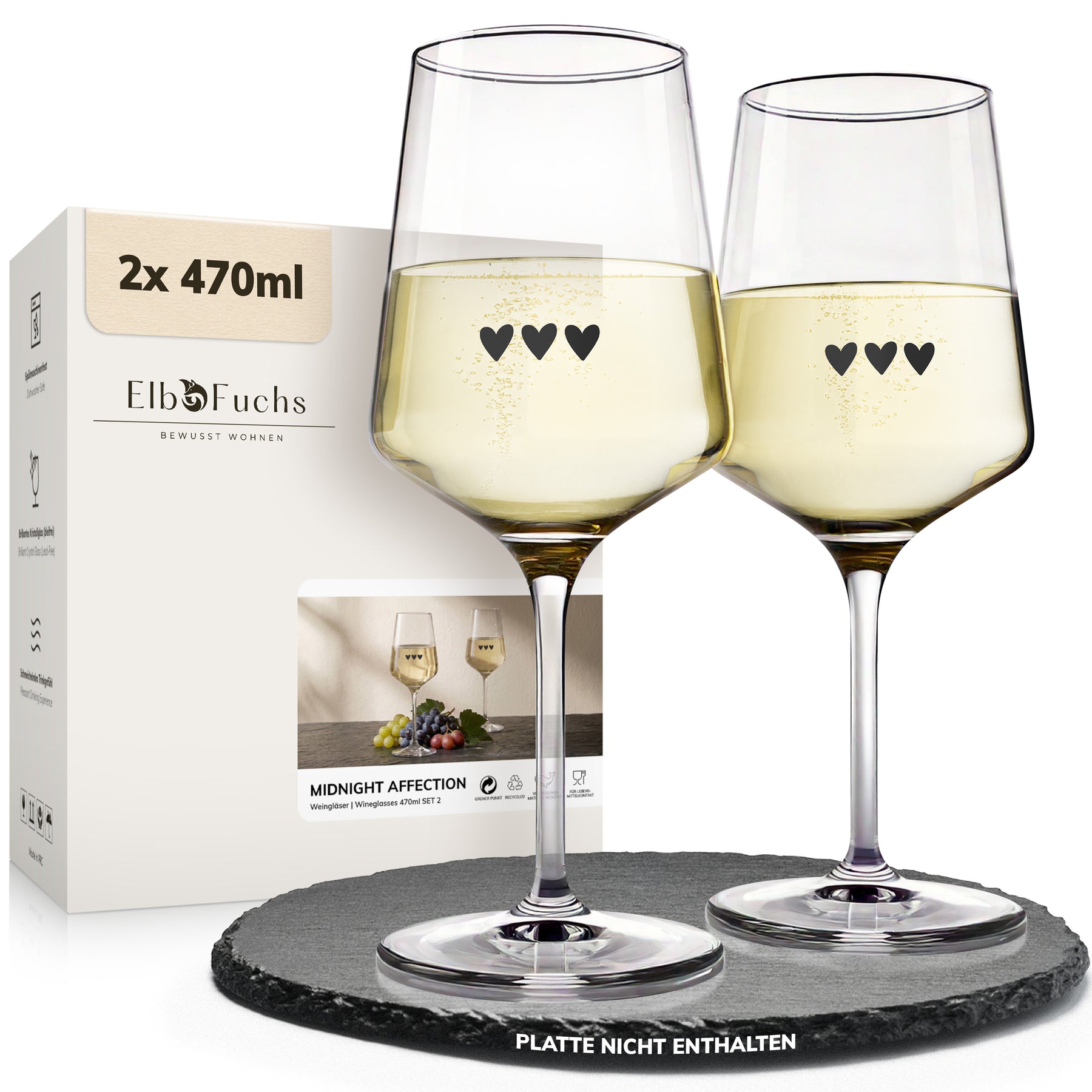 Zwei ElbFuchs Weingläser 'Midnight Affection' mit 470 ml Fassungsvermögen und drei kleinen Herzgravuren stehen gefüllt mit Weißwein neben der Verpackung des 2er-Sets auf einer runden dunklen Schieferplatte.