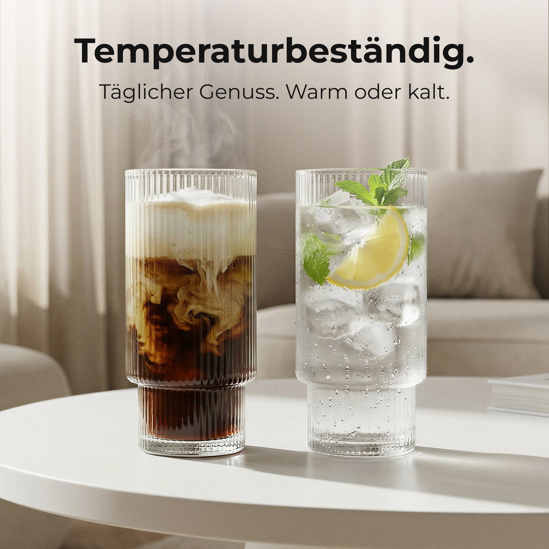 Zwei ElbFuchs RILA Gläser auf einem Couchtisch im Wohnzimmer, eines gefüllt mit cremigem Iced Coffee, das andere mit Zitronen-Minz-Wasser und Eiswürfeln, dazu der Hinweis auf die Temperaturbeständigkeit der Gläser.