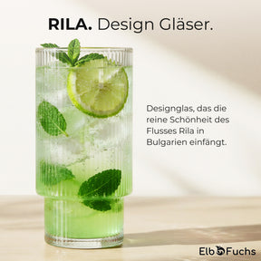 Ein ElbFuchs RILA Designglas mit einem erfrischenden Getränk aus Limette, Minze und Eiswürfeln auf einem Holztisch, der Text verweist auf die Inspiration durch den Fluss Rila in Bulgarien.